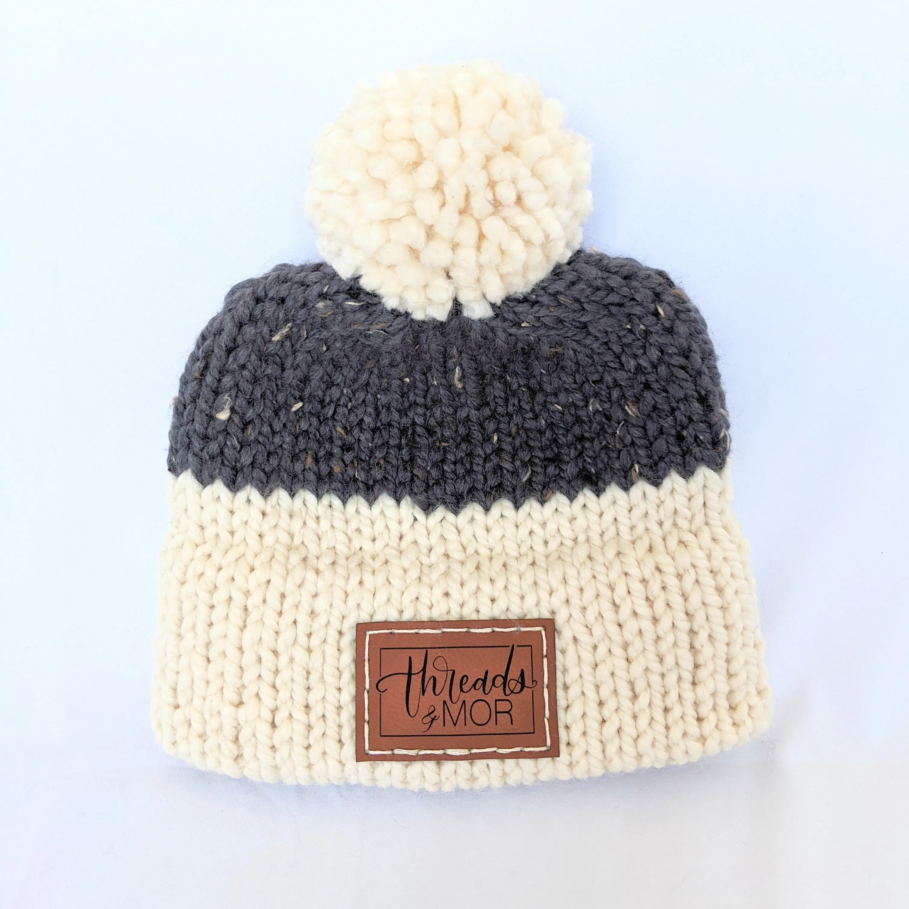 Gray and cream double brim knit hat with yarn pompom